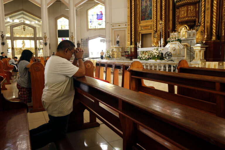 a man kneeling down on prayer in a church