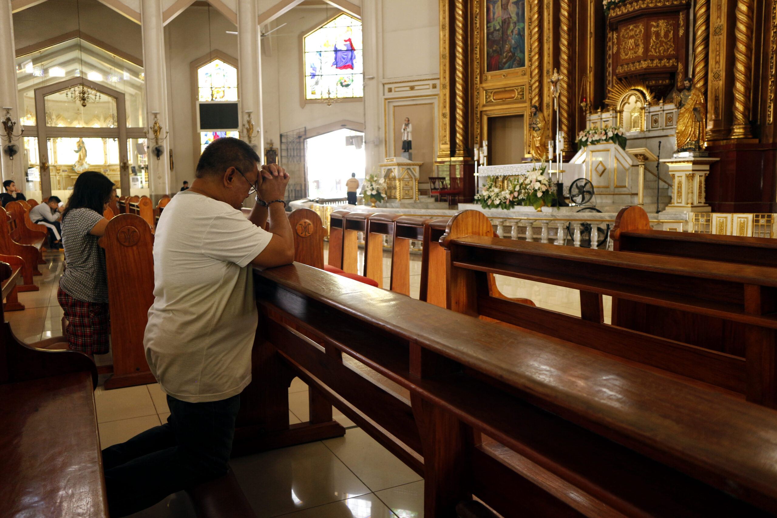 a man kneeling down on prayer in a church